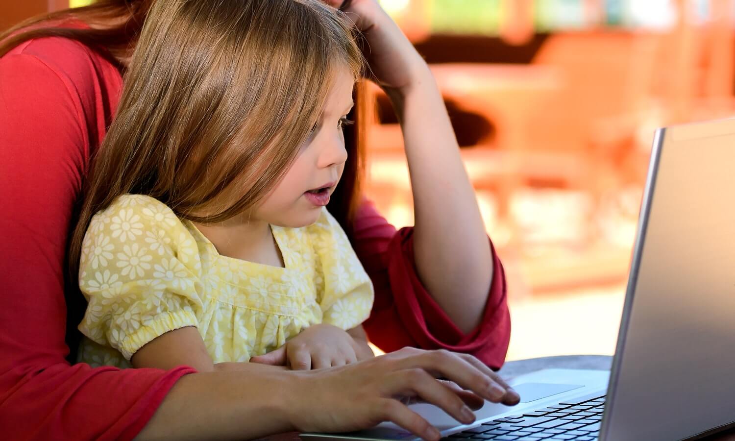 mother-young-daughter-behind-computer