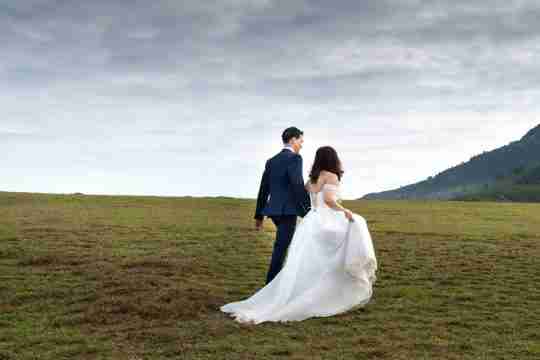 interracial-couple-bride-groom-walking-in-their-wedding-outfits