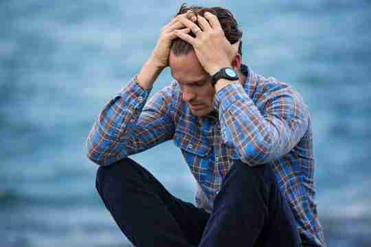 man-in-blue-and-brown-plaid-dress-shirt-touching-his-hair-