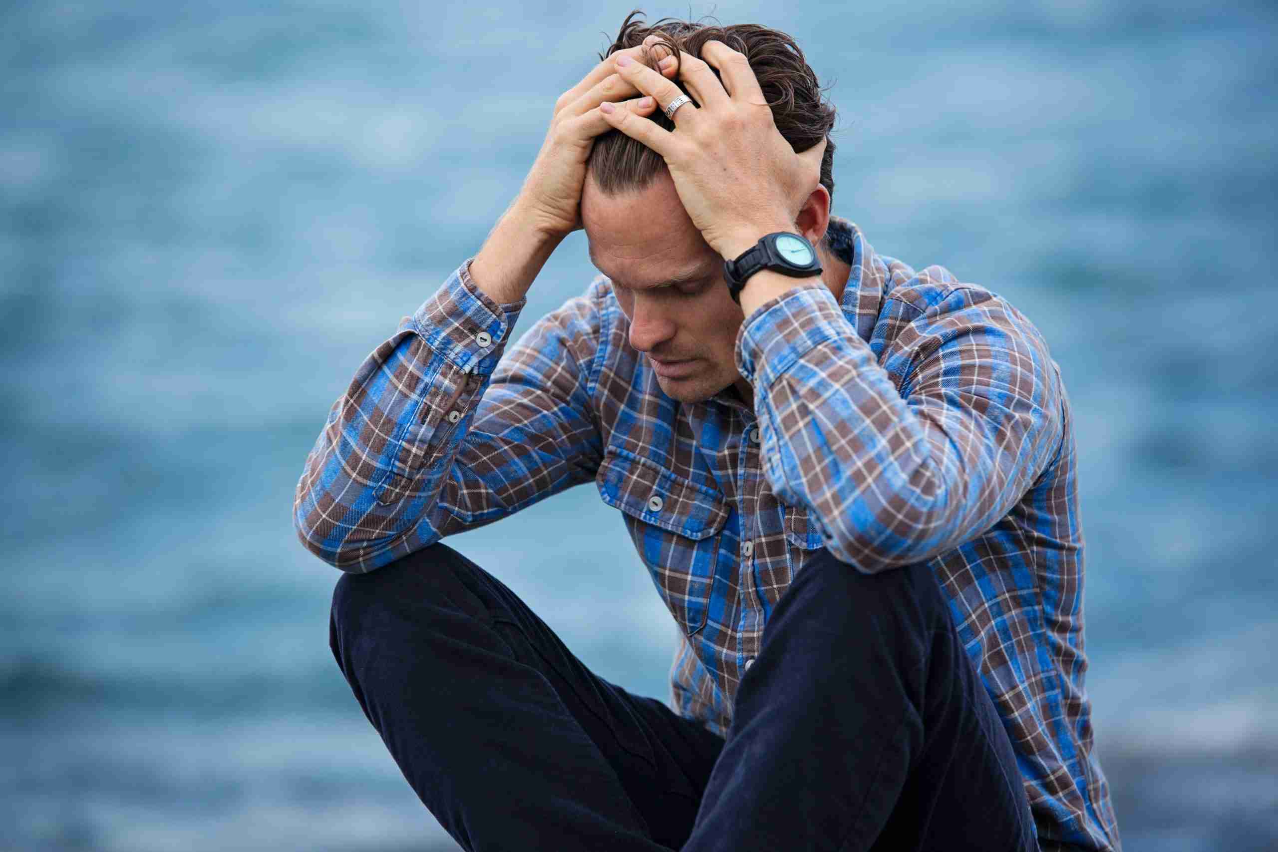 man-in-blue-and-brown-plaid-dress-shirt-touching-his-hair-