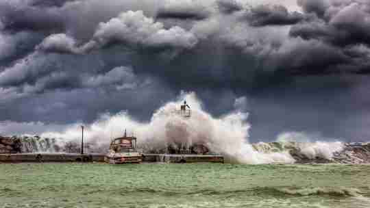 metre-high waves crash over the quay