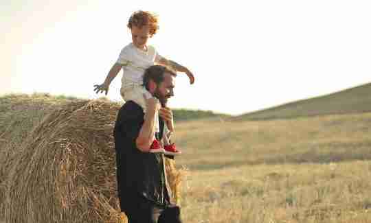 father-giving-son-piggyback-ride-in-field
