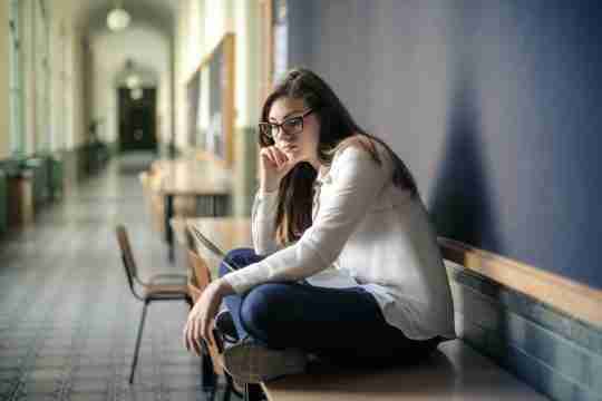 woman-in-white-long-sleeve-shirt-and-blue-denim-jeans-sitting-on-table