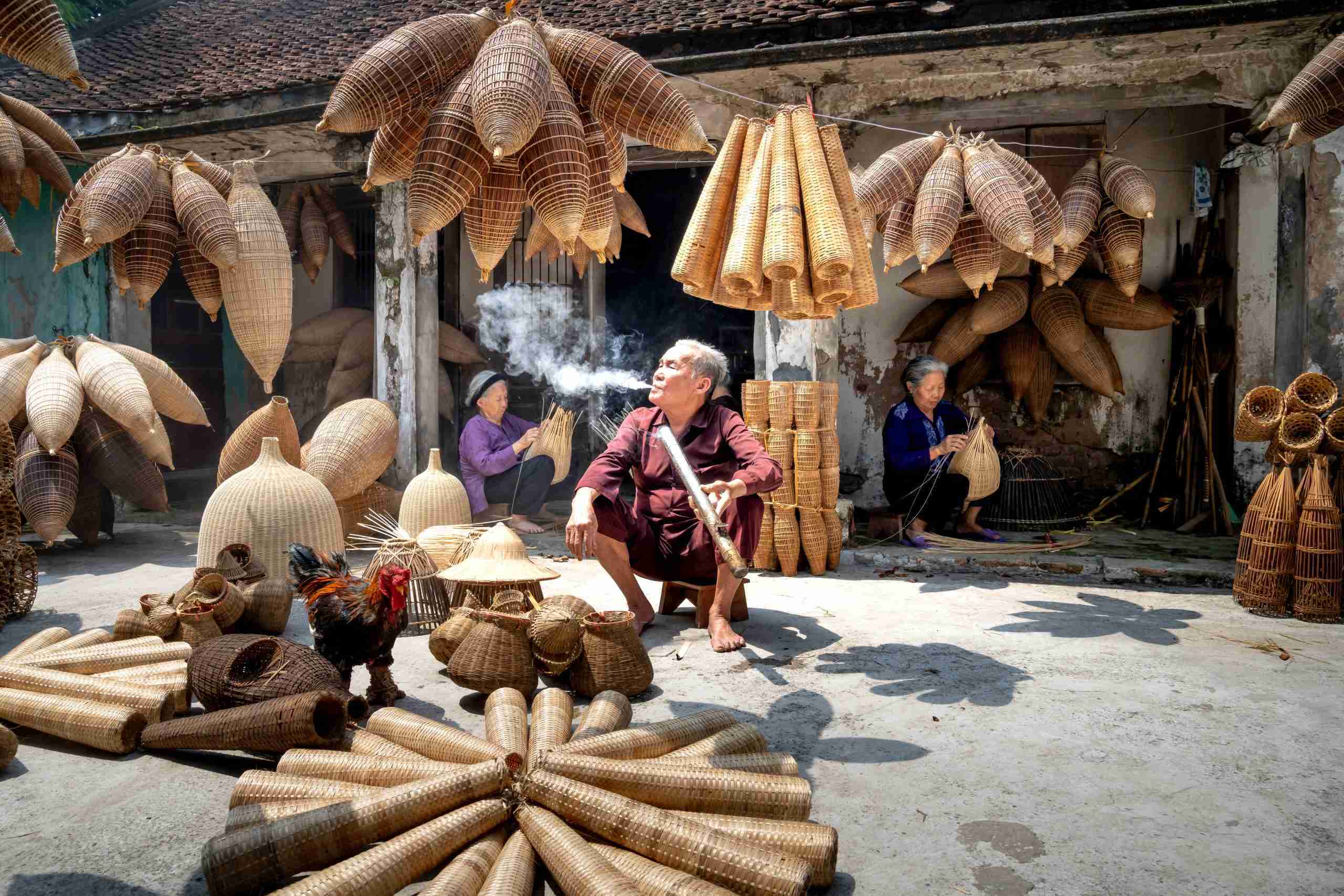 vietnamese-man-smoking-among-women-working-on-bamboo-fish-traps